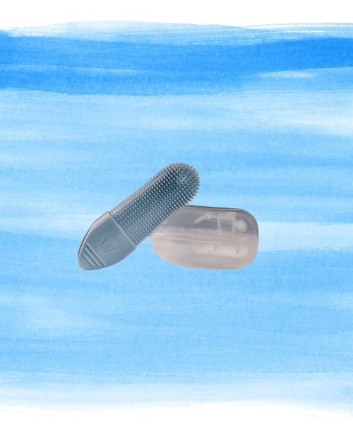 A blue silicone finger brush tool with dense bristles and a translucent clear case, shown floating against a watercolor-style blue background.